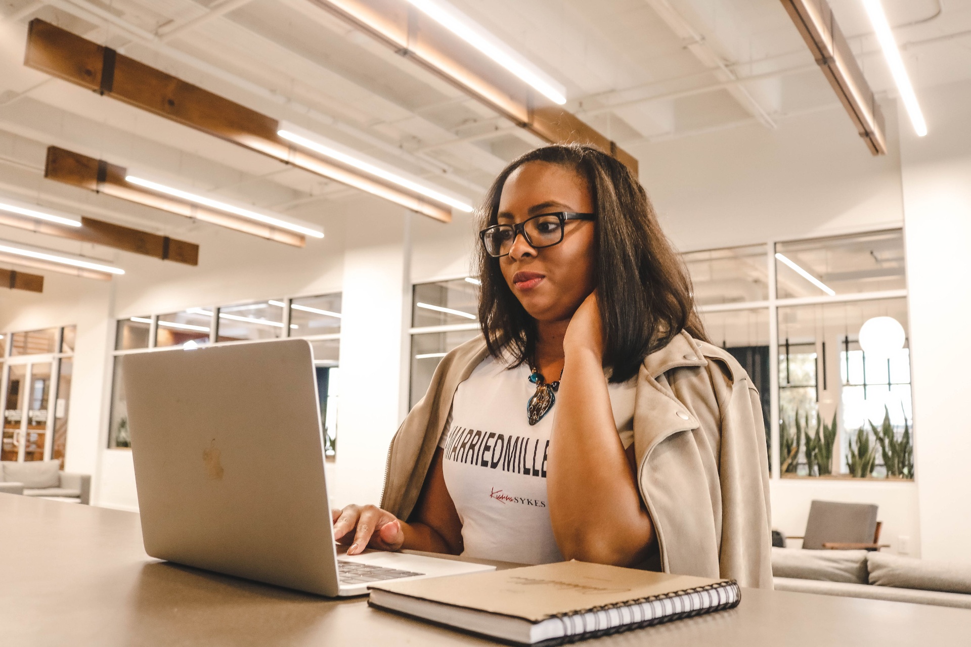 Kiarra Sykes working on her laptop in a bright modern workspace